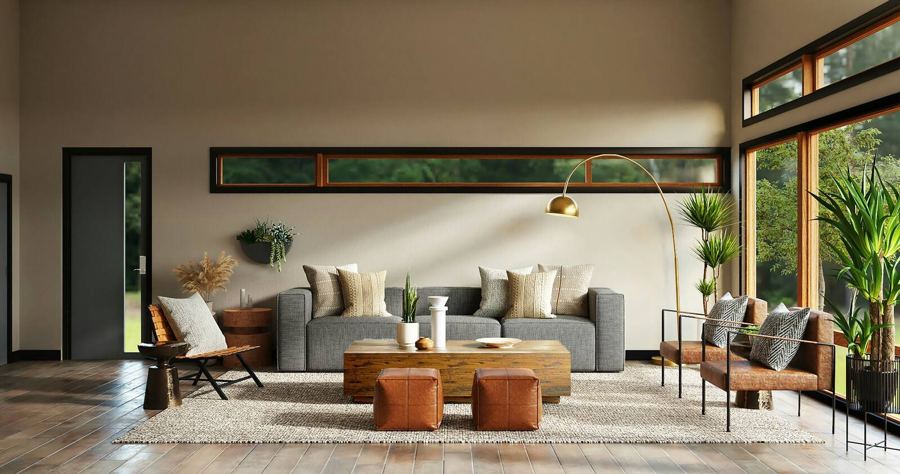 A long, warm living room with low windows, a pale sofa and leather ottomans