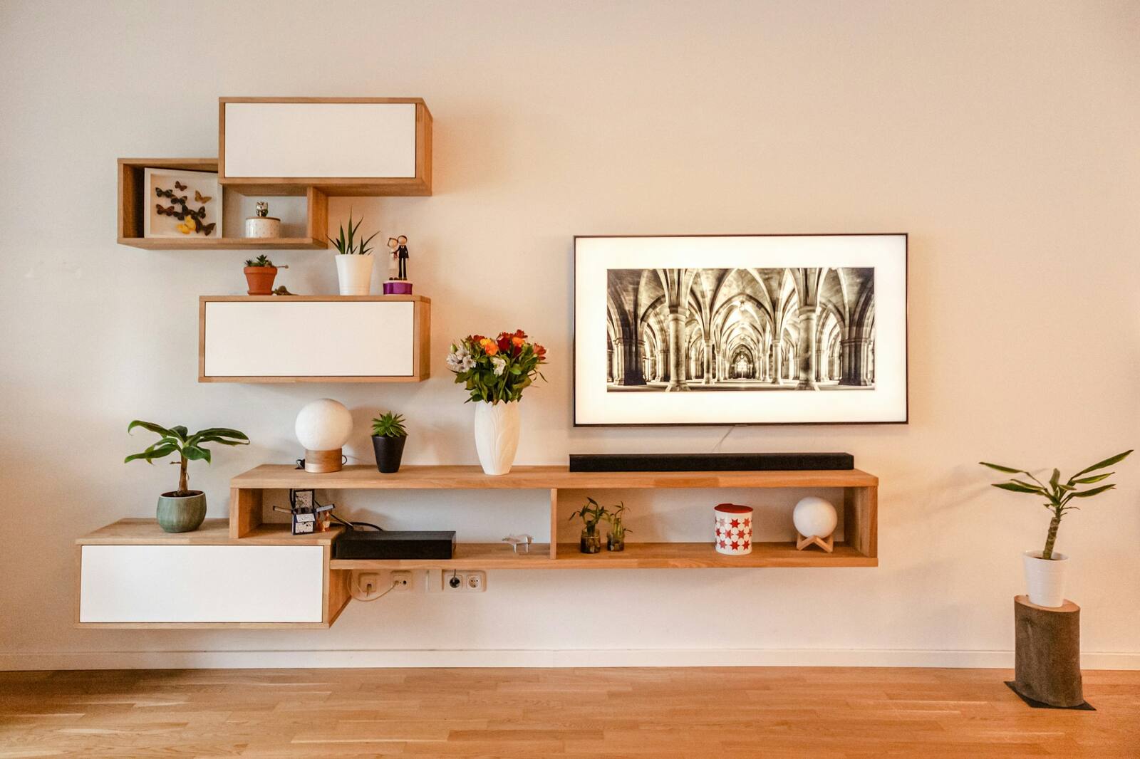 Neatly styled floating shelves with books, plants and a few objects